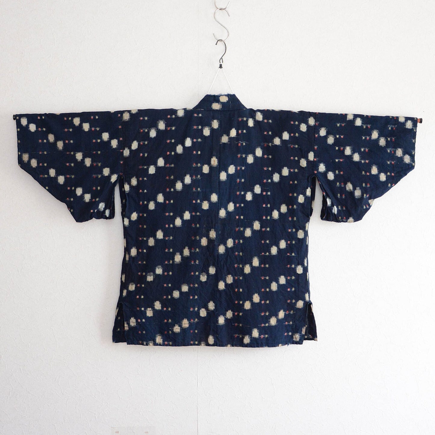 Back view of a vintage noragi displayed on a kimono hanger