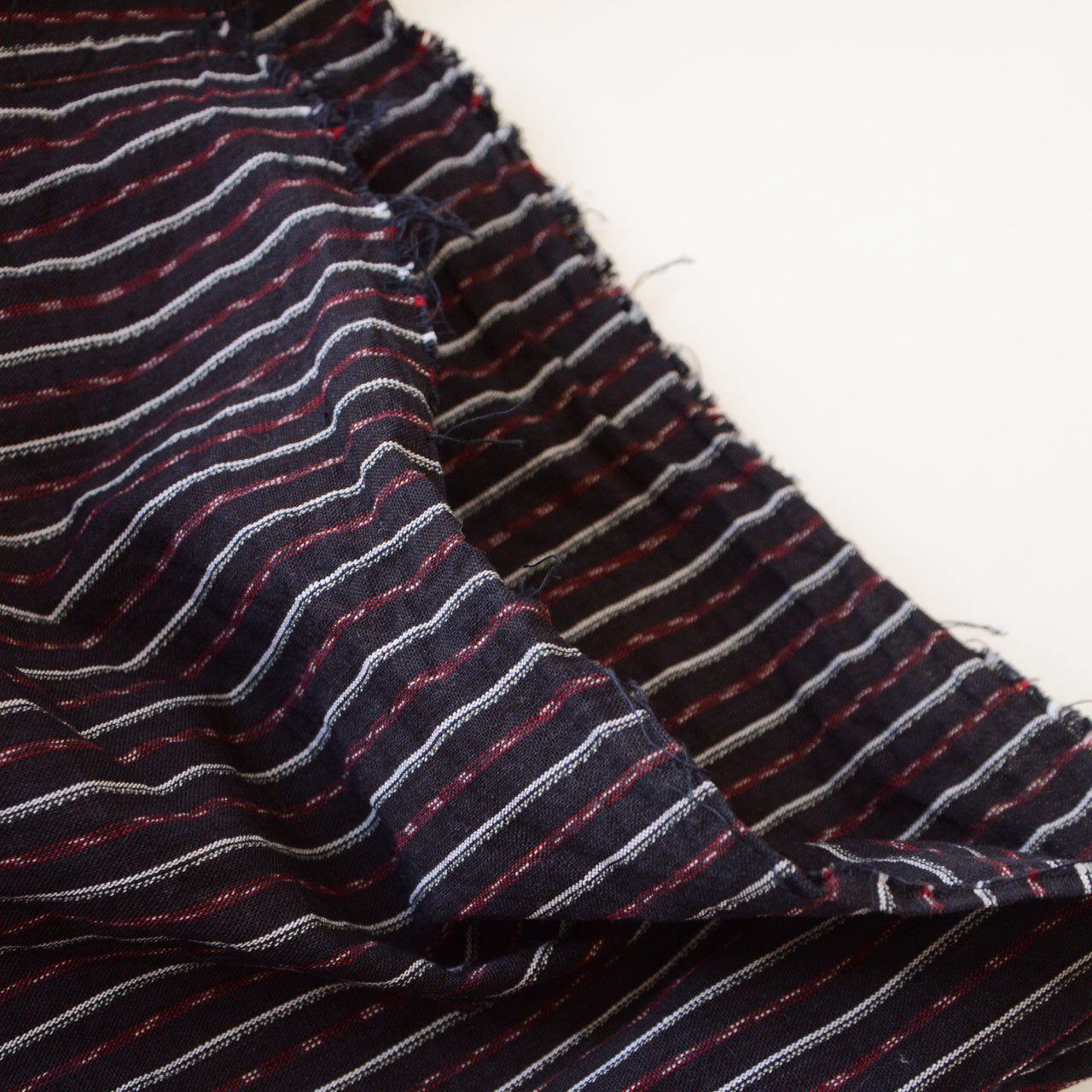 Close-up of the cropped waist of vintage Japanese monpe pants made from striped cotton fabric. The raw, unfinished waist adds to the relaxed, rugged aesthetic.