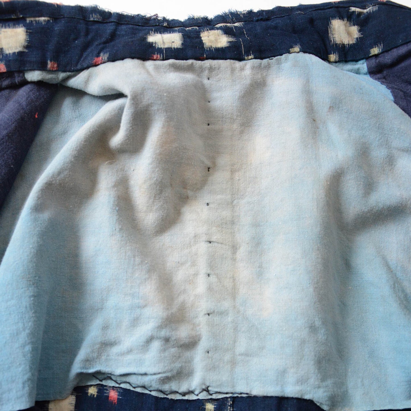 Detailed view of the faded inner lining of a traditional noragi, emphasizing its aged beauty