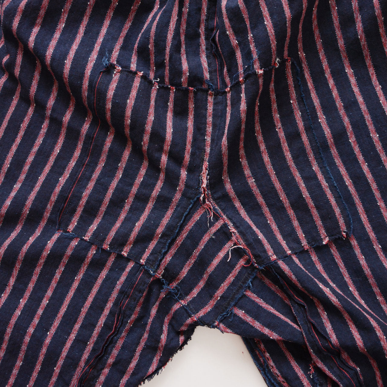 Indigo striped monpe pants styled as casual wear with metal ankle hooks