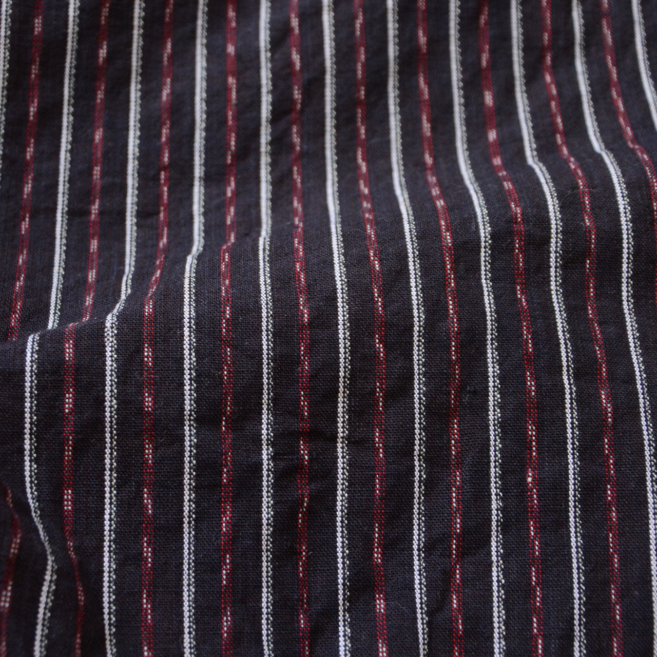 Close-up of the striped cotton fabric of vintage Japanese monpe pants, highlighting the texture and unique charm of this traditional Japanese fabric, which is highly sought after globally.