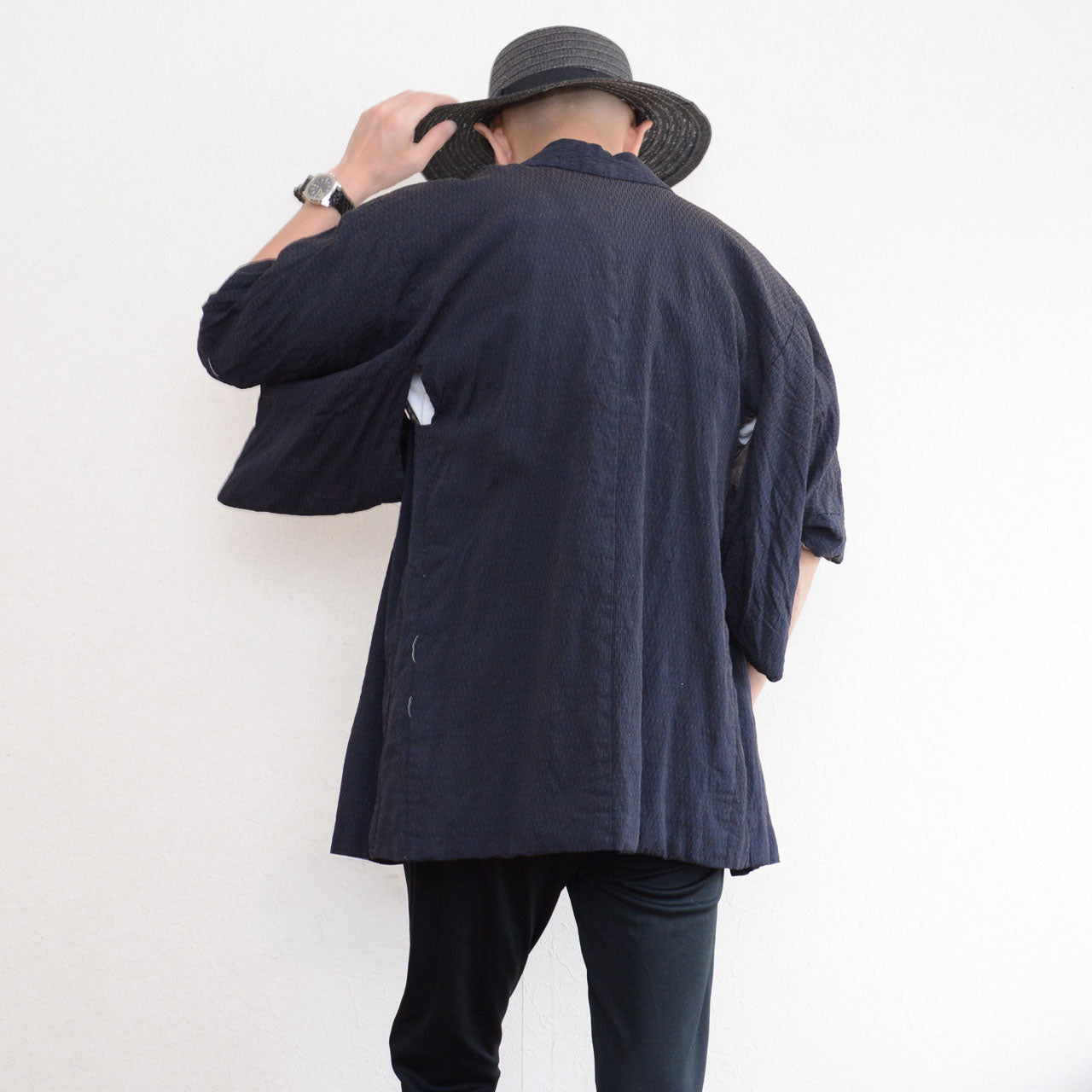 Male model wearing a deep navy Japanese vintage haori kimono jacket, viewed from the back