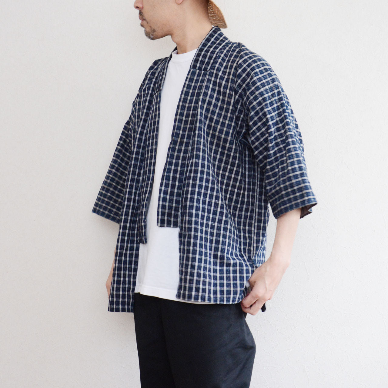 Vintage noragi jacket worn by a male model, side view — indigo-dyed cotton check, open-front silhouette, early Showa era Japan vintage