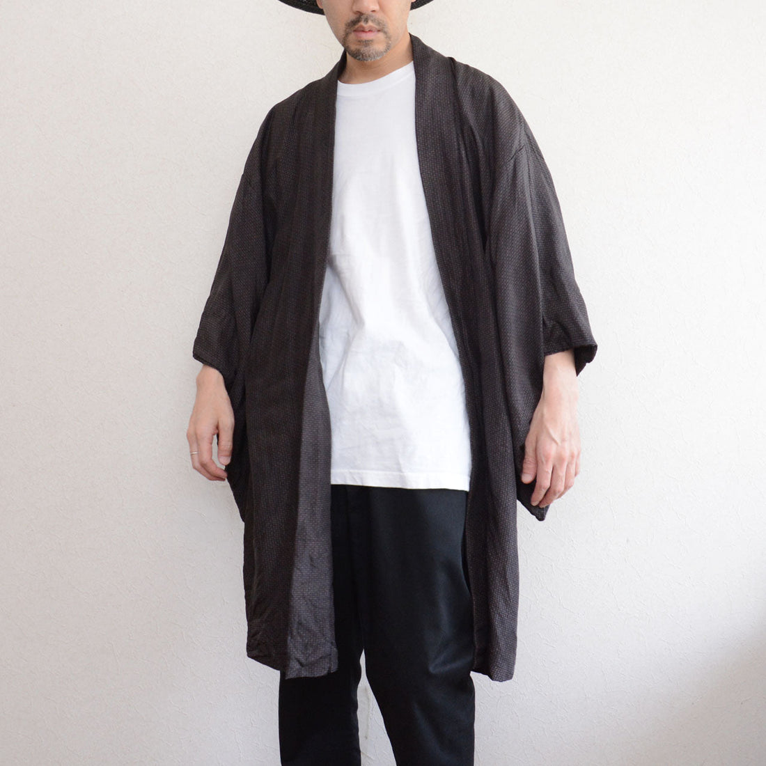 Male model wearing vintage haori jacket, front view, komon pattern, dark silk blend, wide sleeve silhouette, styled with contemporary outfit