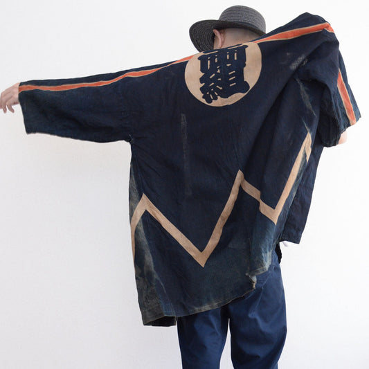 Firefighter hanten worn with arms extended, showing the back crest and pale zigzag pattern