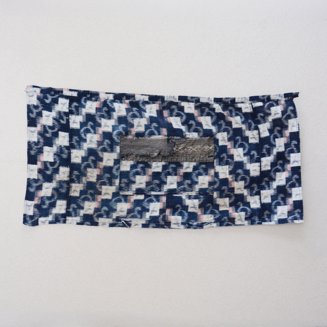 Mid-Showa Japanese vintage indigo cotton fabric with white angular and curved kasuri motifs, red accents and a remaining central pocket
