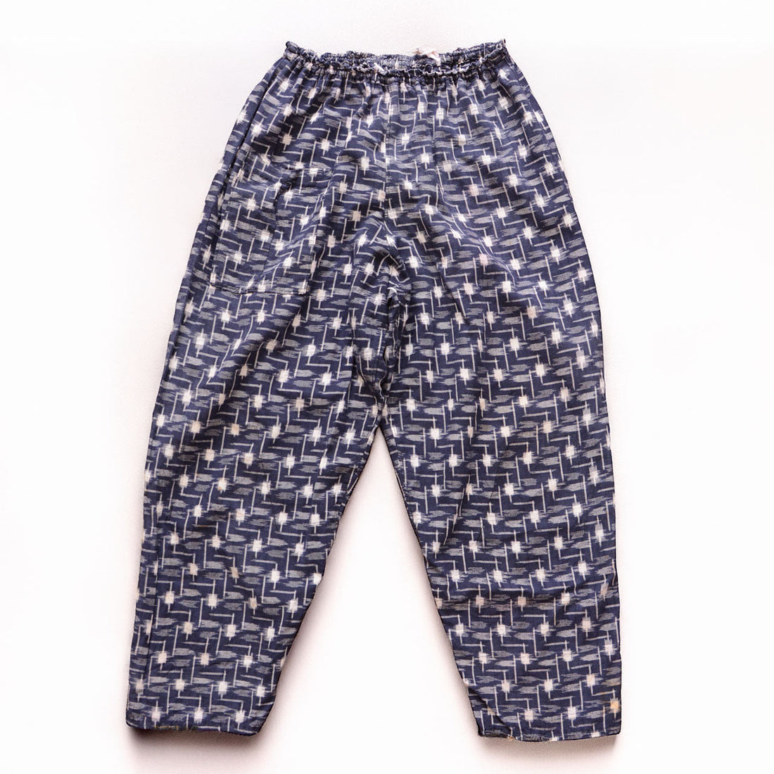Vintage kasuri monpe pants, front view, navy cotton with white geometric ikat pattern, elastic waist, wide-leg silhouette, mid-Showa era Japan