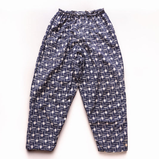 Vintage kasuri monpe pants, front view, navy cotton with white geometric ikat pattern, elastic waist, wide-leg silhouette, mid-Showa era Japan