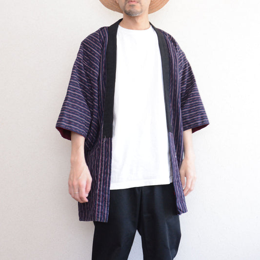 Navy cotton stripe noragi jacket worn, front view, styled over white tee and black trousers