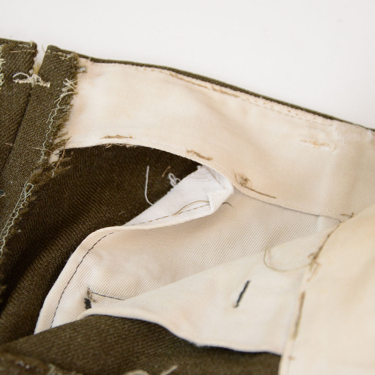Vintage wool pants with missing belt loops and mil-spec marks cut