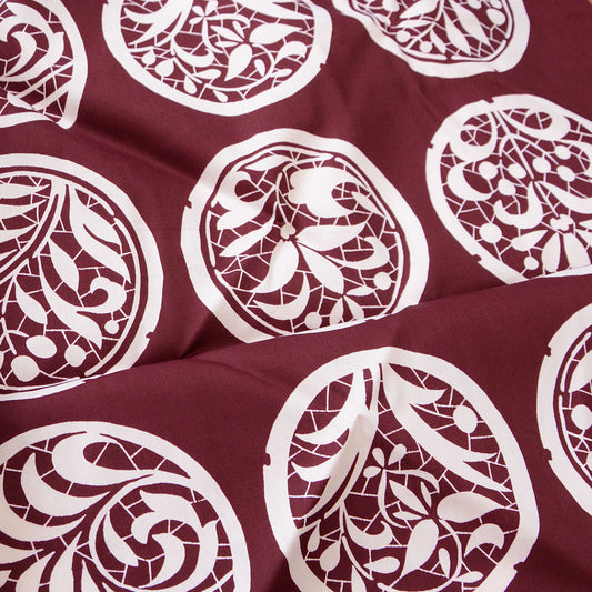 Vintage Japanese furoshiki with botanical crest motifs on burgundy cotton fabric