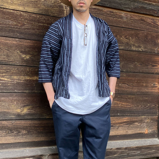 Man wearing an indigo-dyed vintage Japanese noragi jacket paired with a casual white T-shirt, showcasing a blend of traditional workwear and modern style.