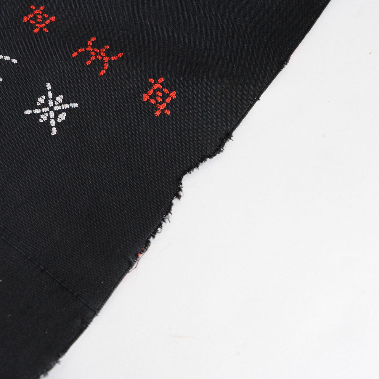 Embroidered patterns applied to plain-woven cotton fabric