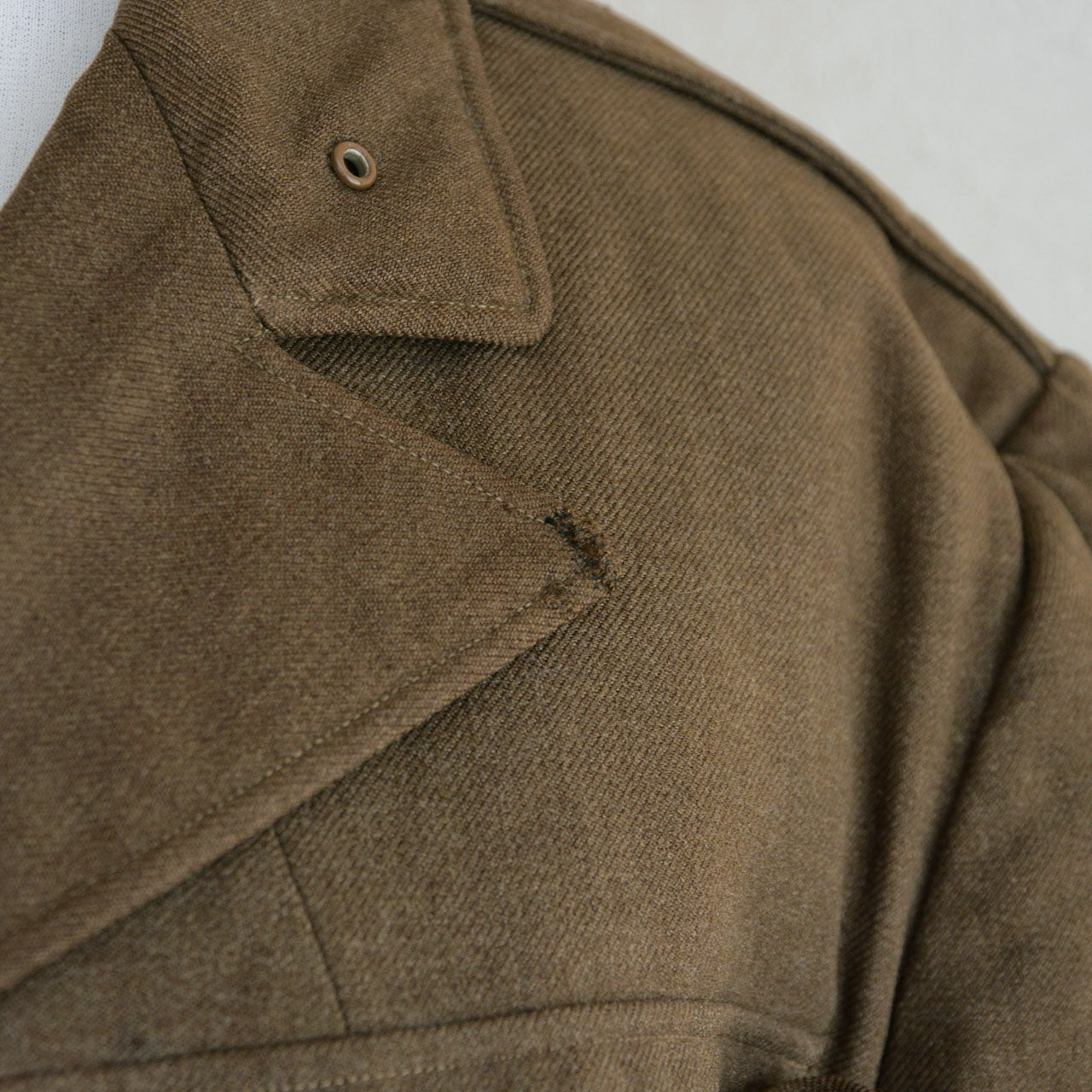 A U.S. Army officer jacket featuring mixed and replaced button hardware.