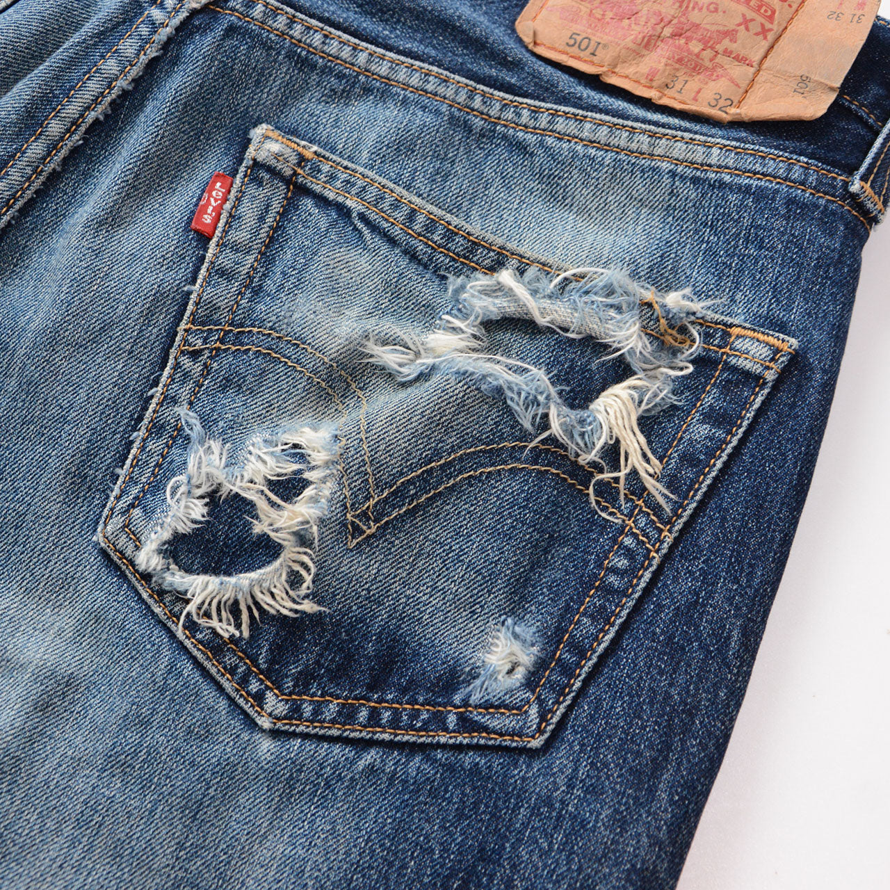Levi's 501, aged blue denim with natural color variation, frayed hem, vintage condition
