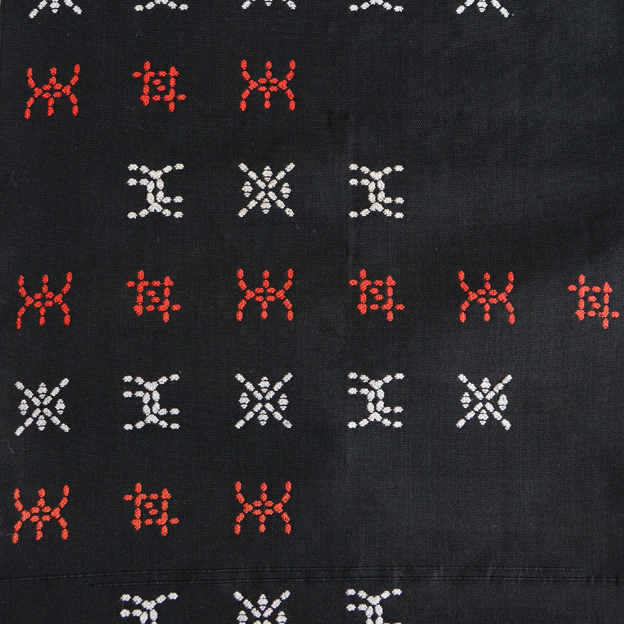 Detail of textured embroidery on thick cotton fabric with visible stitching