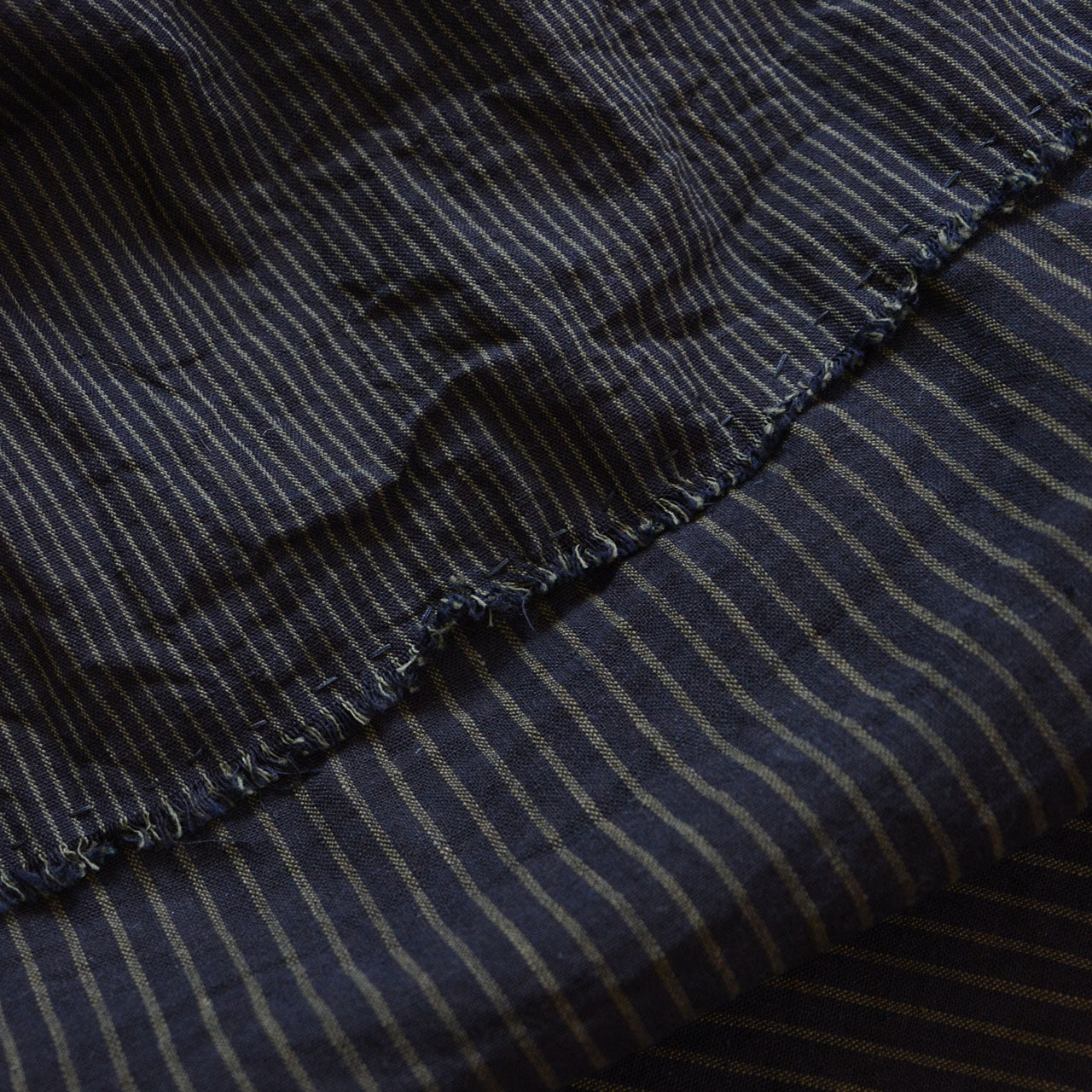 Striped patchwork textile with rustic hand-finished seams