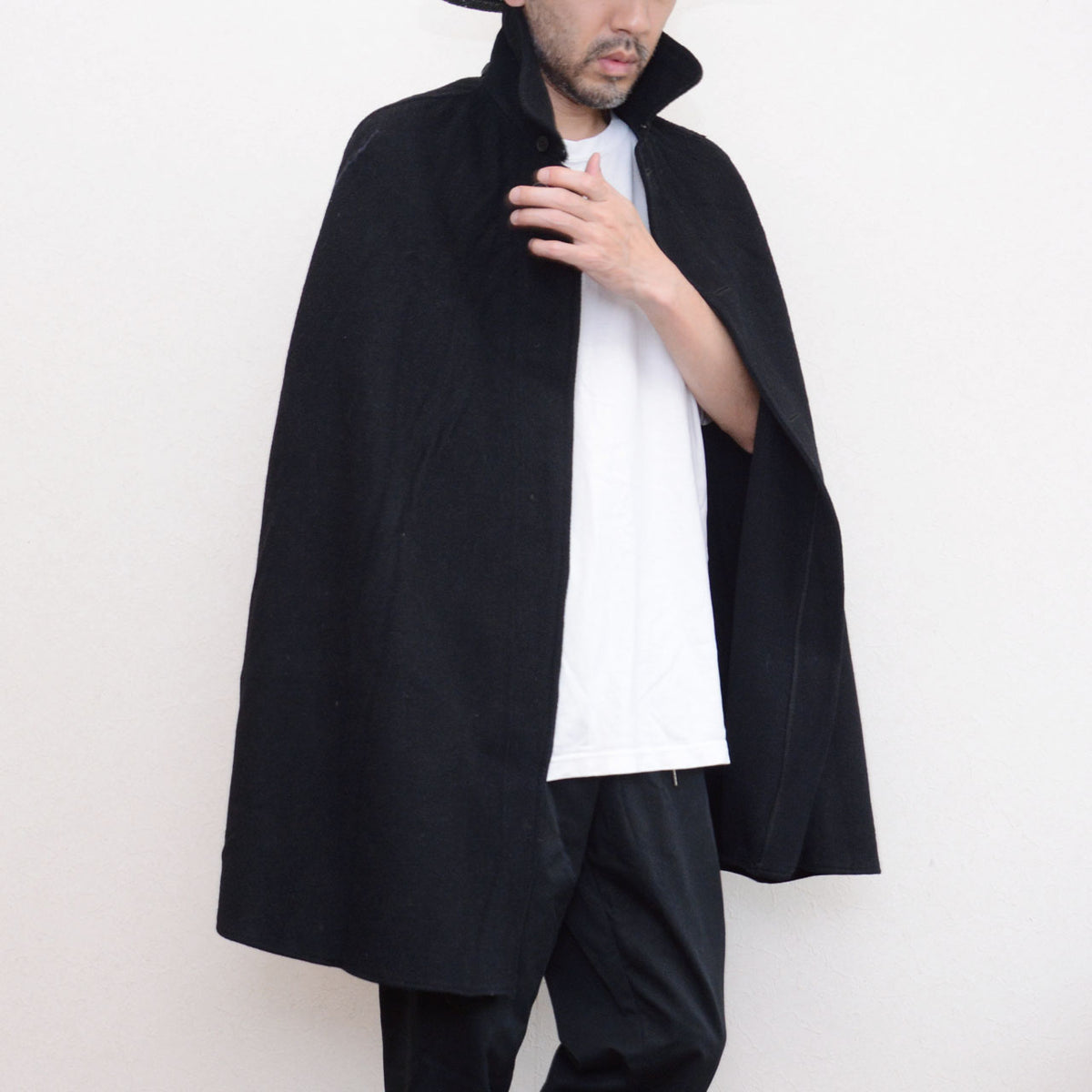 Front of black wool Bankara mantle worn with raised collar by 171 cm model in motion