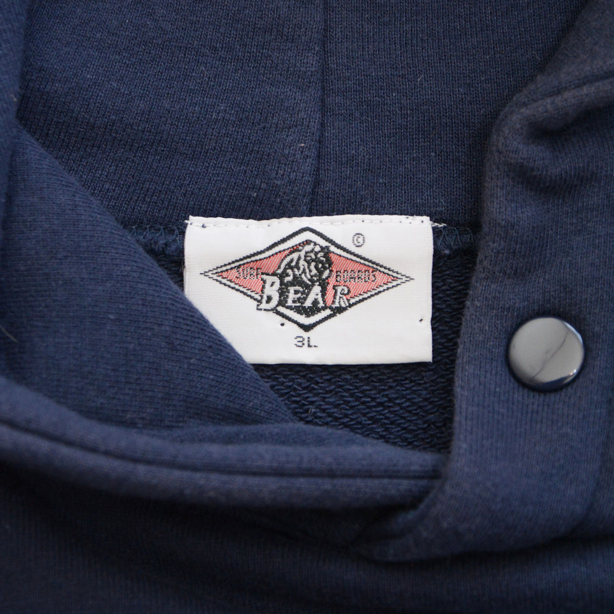 BEAR brand neck label showing size 3L on navy hoodie