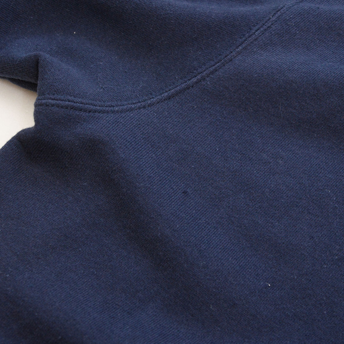 Worn area of navy cotton fabric on BEAR SURFBOARDS hoodie