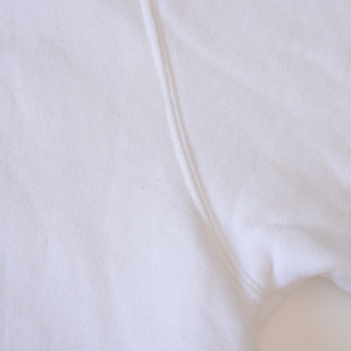 Abrasion near a seam on white BEAR SURFBOARDS vintage sweatshirt
