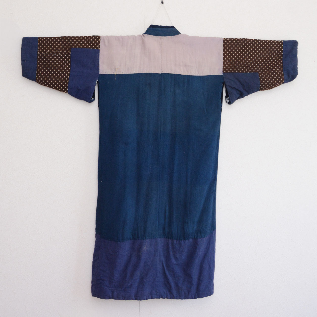 Back side of vintage Japanese hanten padded jacket on hanger, rear view