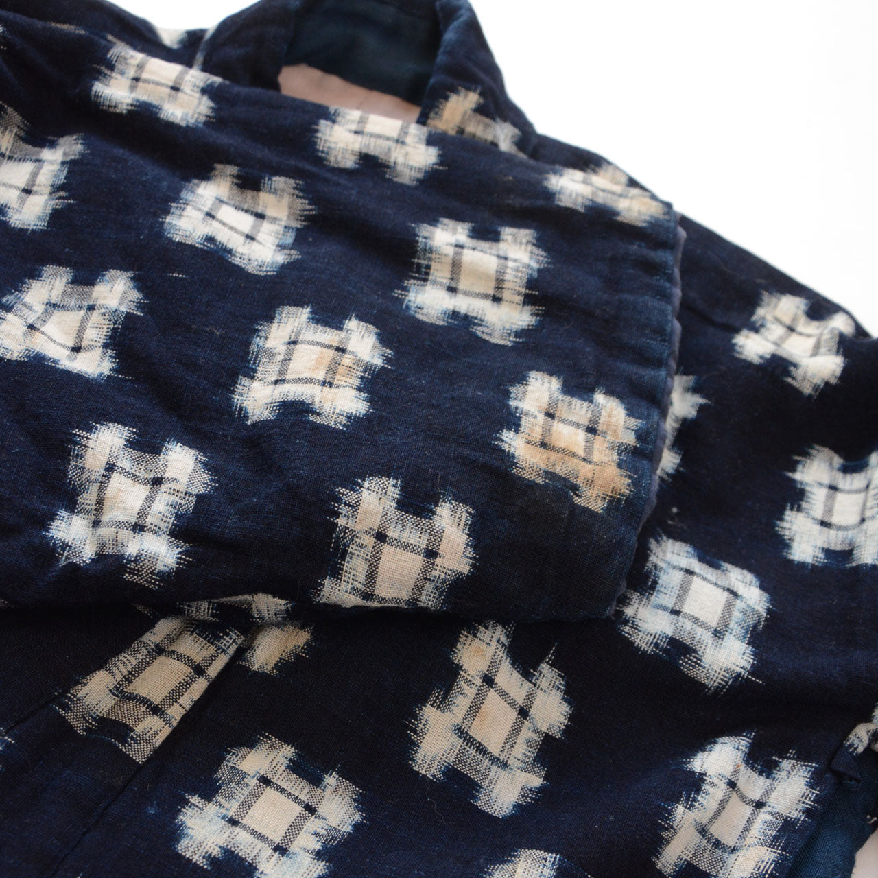 Close-up of shoulder and sleeve folded, showing cotton batting volume and staining, vintage hanten padded jacket