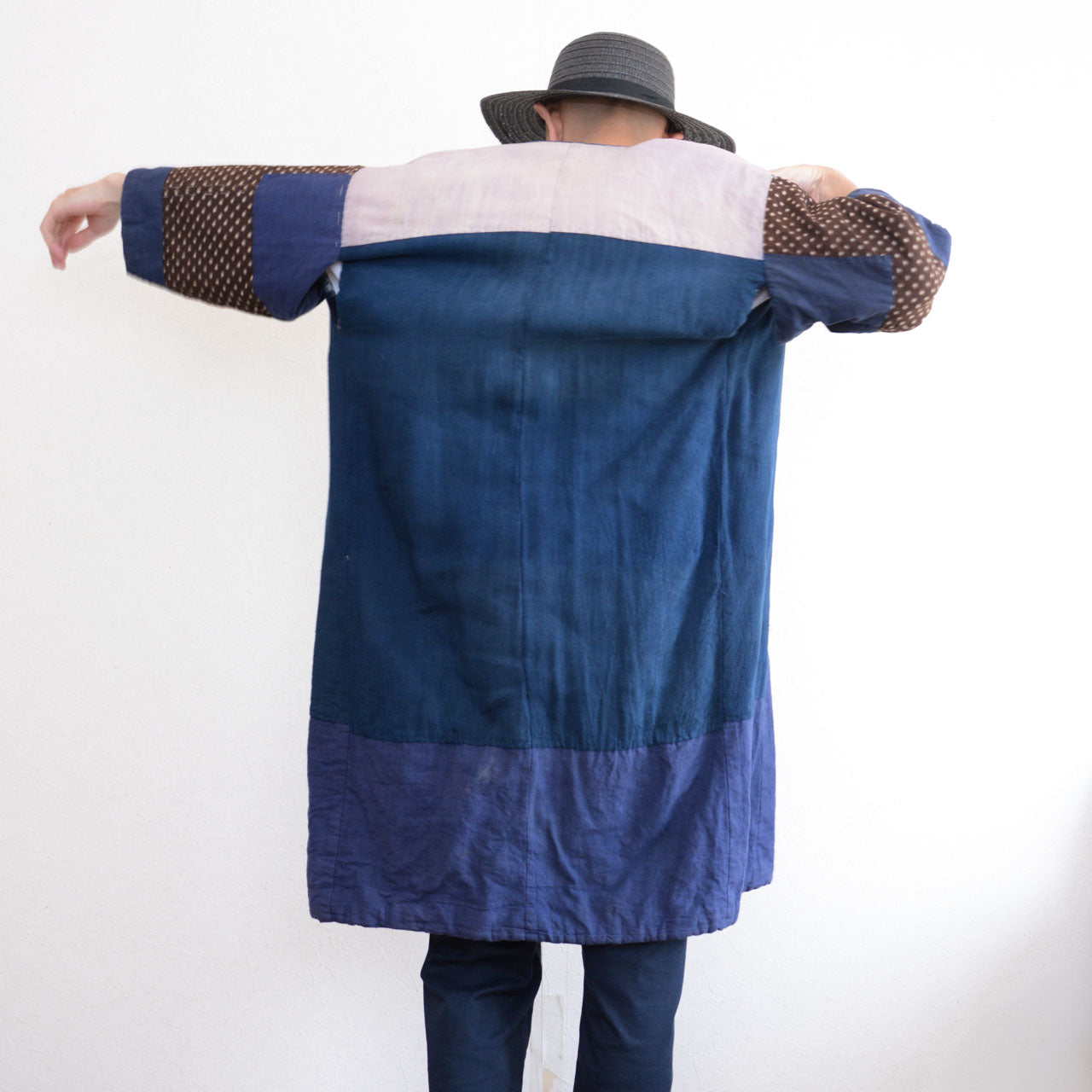 Model wearing vintage Japanese hanten padded jacket, back view, arms spread, showing full silhouette