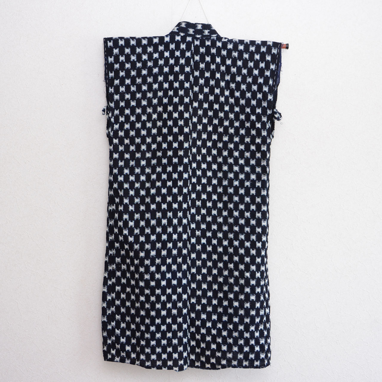 Indigo kasuri cotton haori vest on hanger, navy and white ikat weave pattern, back view