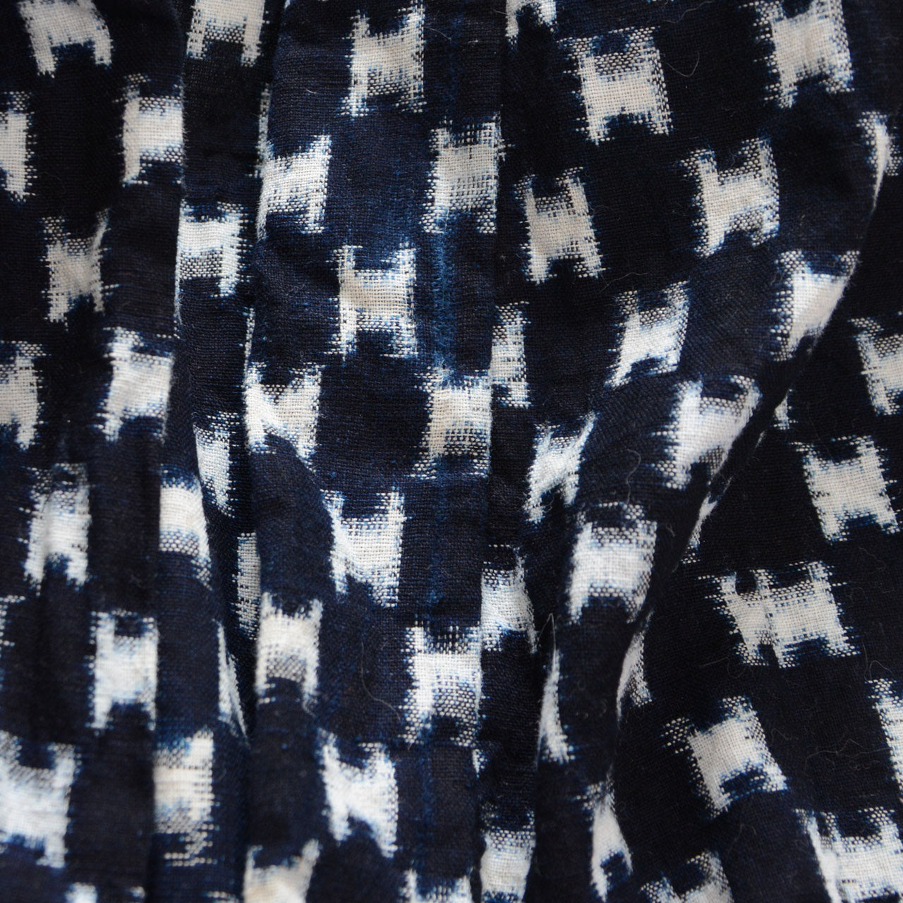 Natural indigo fading and surface wear on kasuri cotton fabric, vintage patina detail