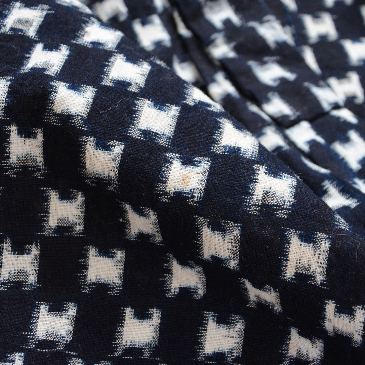 Minor surface soiling on indigo kasuri cotton fabric, vintage wear consistent with age