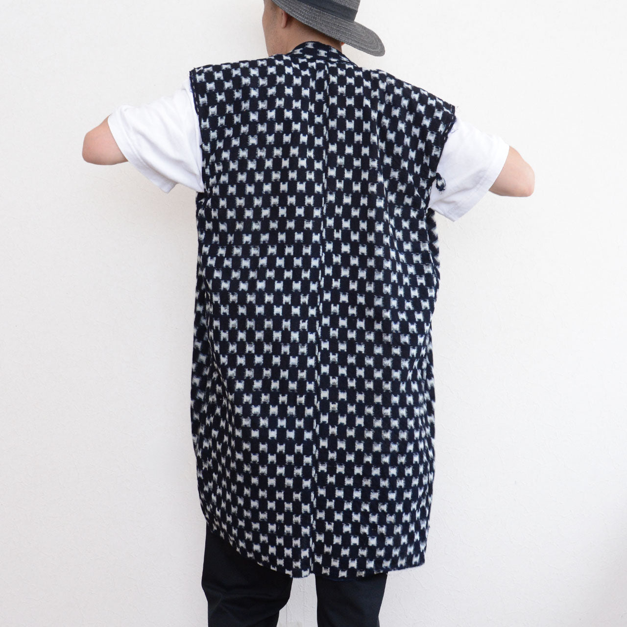 Indigo kasuri sleeveless haori vest styled with white t-shirt, black trousers and brimmed hat, back view