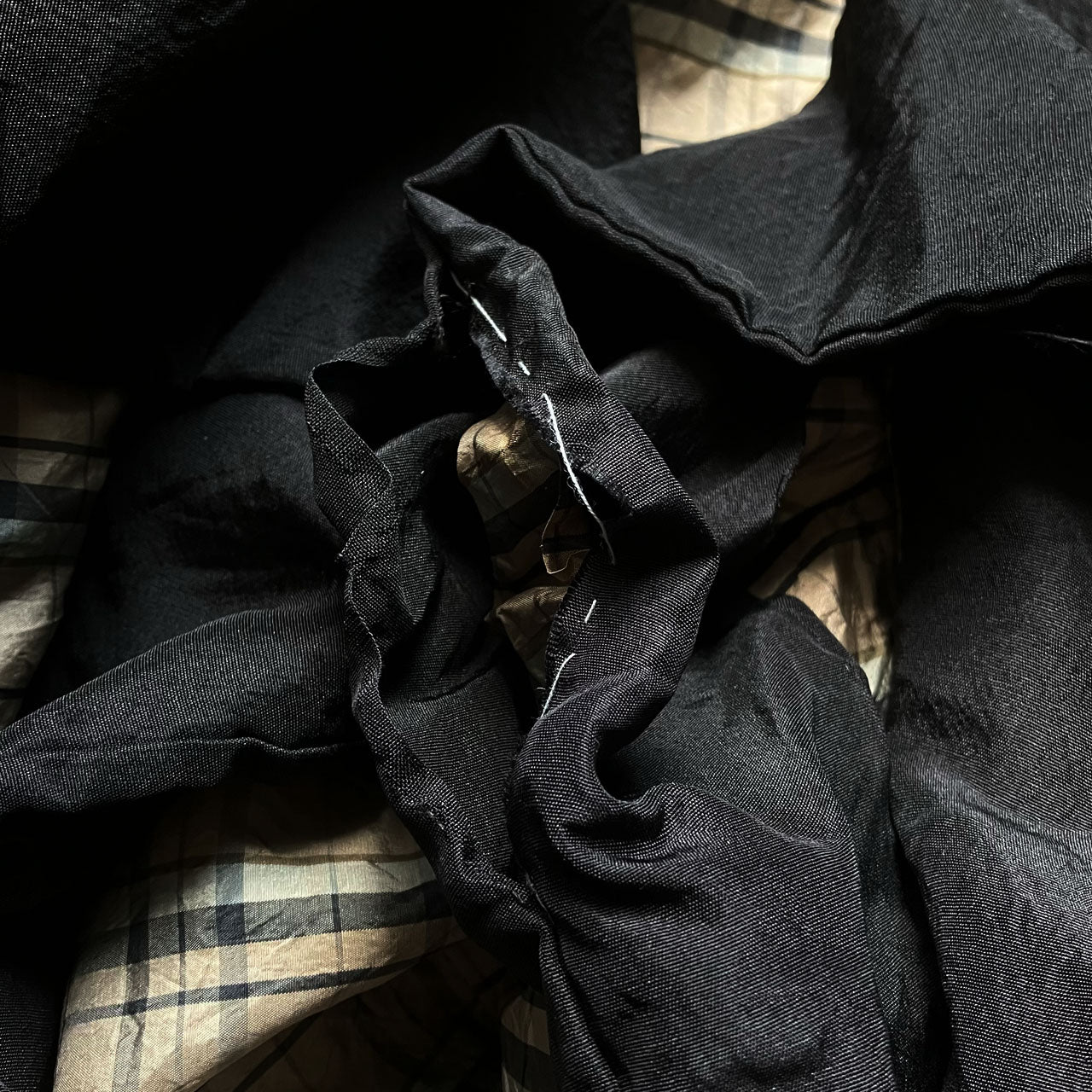 Close-up of haori sleeve cuff showing fraying condition and chi loop attachment point, checkered lining detail visible