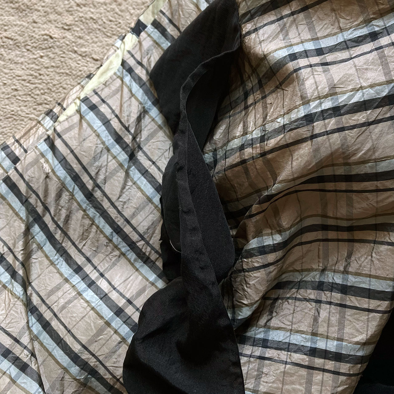 Close-up of haori tartan checkered lining showing beige and black plaid pattern with lustrous sheen, contrasted against black outer fabric, Japan vintage