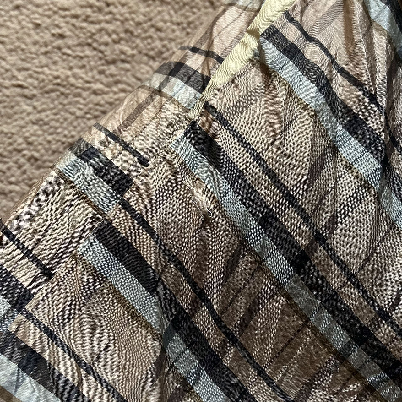 Close-up of haori lining showing small hole and fraying condition detail, beige tartan check fabric, Japan vintage