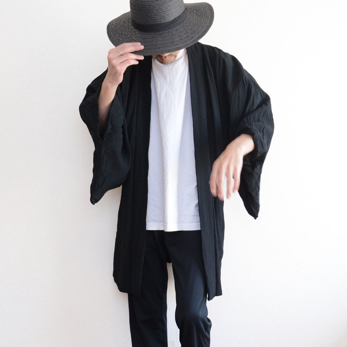 Men's black Japanese vintage haori jacket with wide sleeves, paired with a white T-shirt, black trousers, and a dark hat