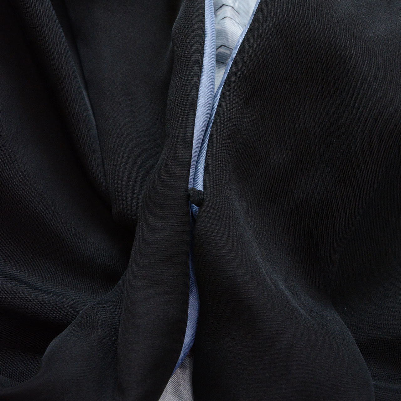 Black silk haori jacket, close detail of center front opening showing pale blue silk lining with hand-painted landscape motif, contrast between black outer fabric and light blue haura interior, Japan vintage