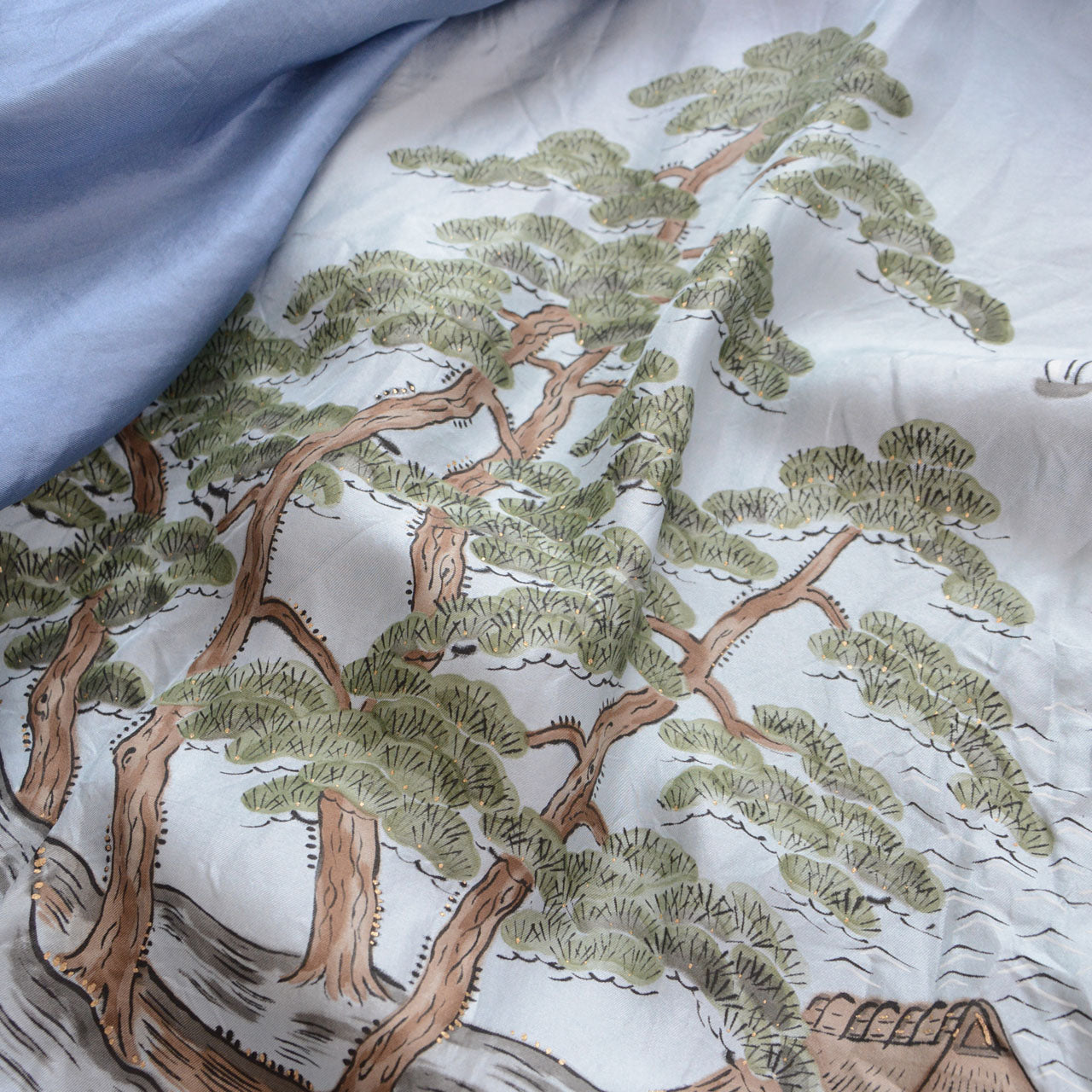Pale blue silk haori lining (haura), close detail of hand-painted pine trees with green foliage and brown trunks, Japanese sansui landscape motif on white-blue silk ground, Japan vintage