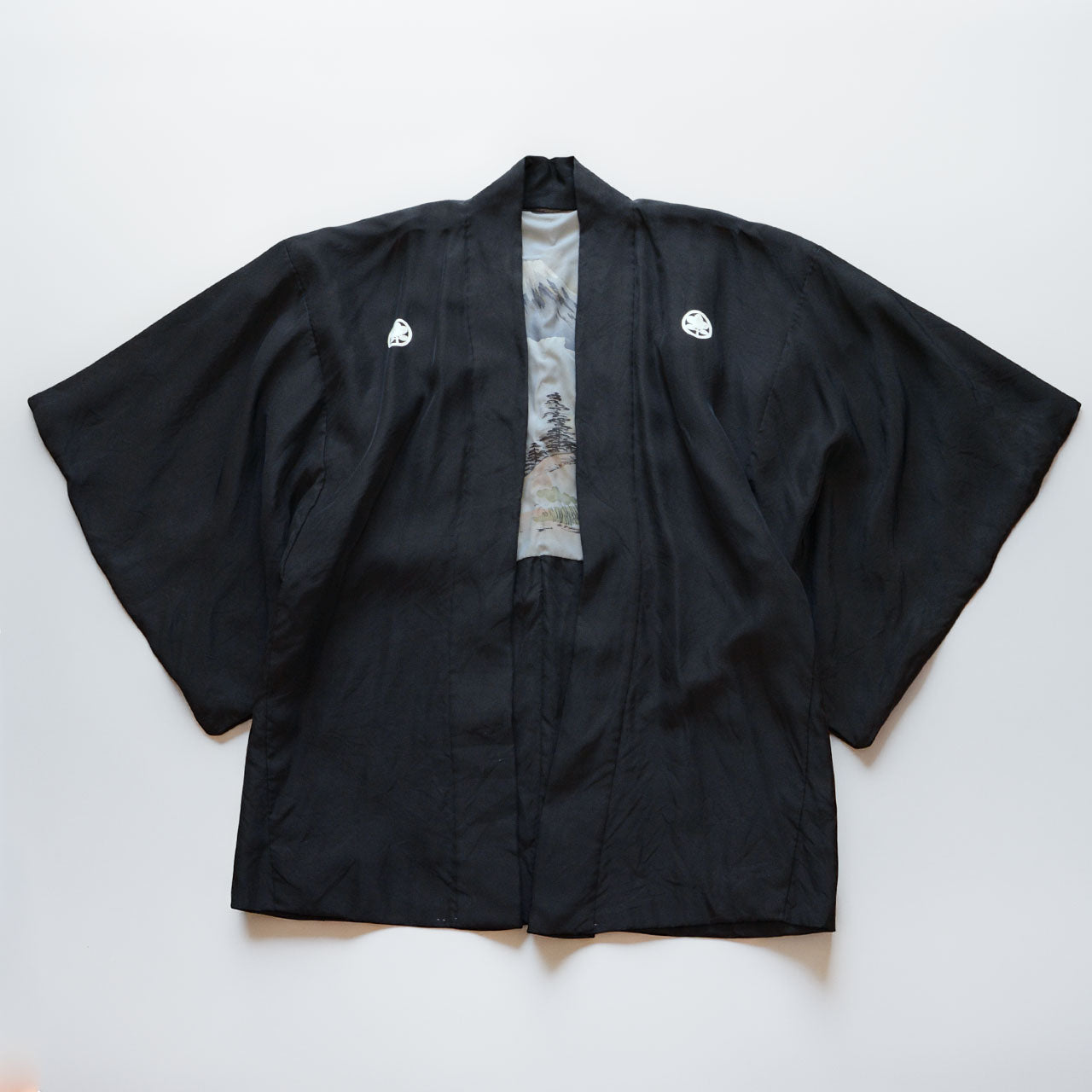 Men's black silk haori jacket with five family crests, laid flat, front view