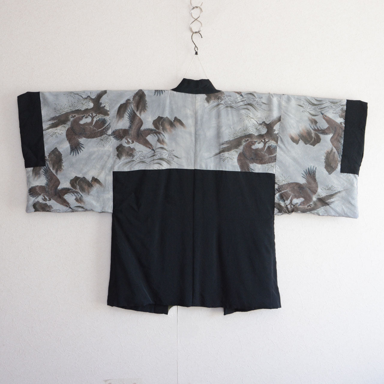 Close-up of haori lining turned inside out, eagle on pine branch, detailed feather rendering, silver-grey silk, Japan vintage