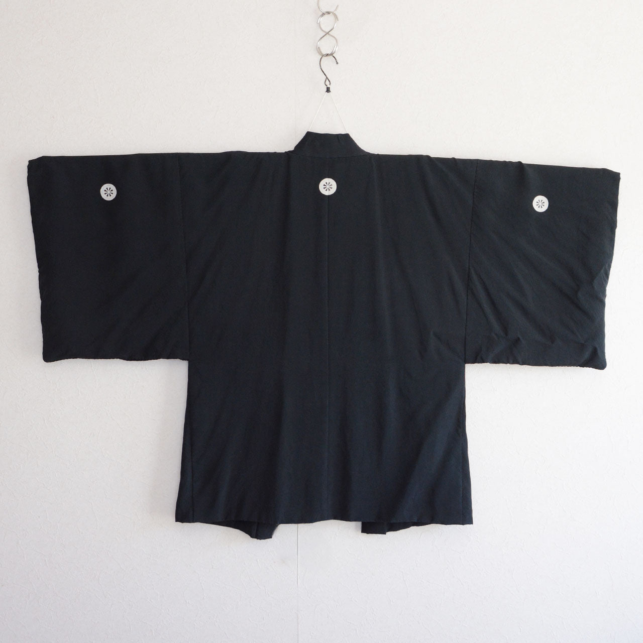 Back view of black silk haori laid flat, pure black silk exterior, five kamon crests, montsuki haori, Japan vintage