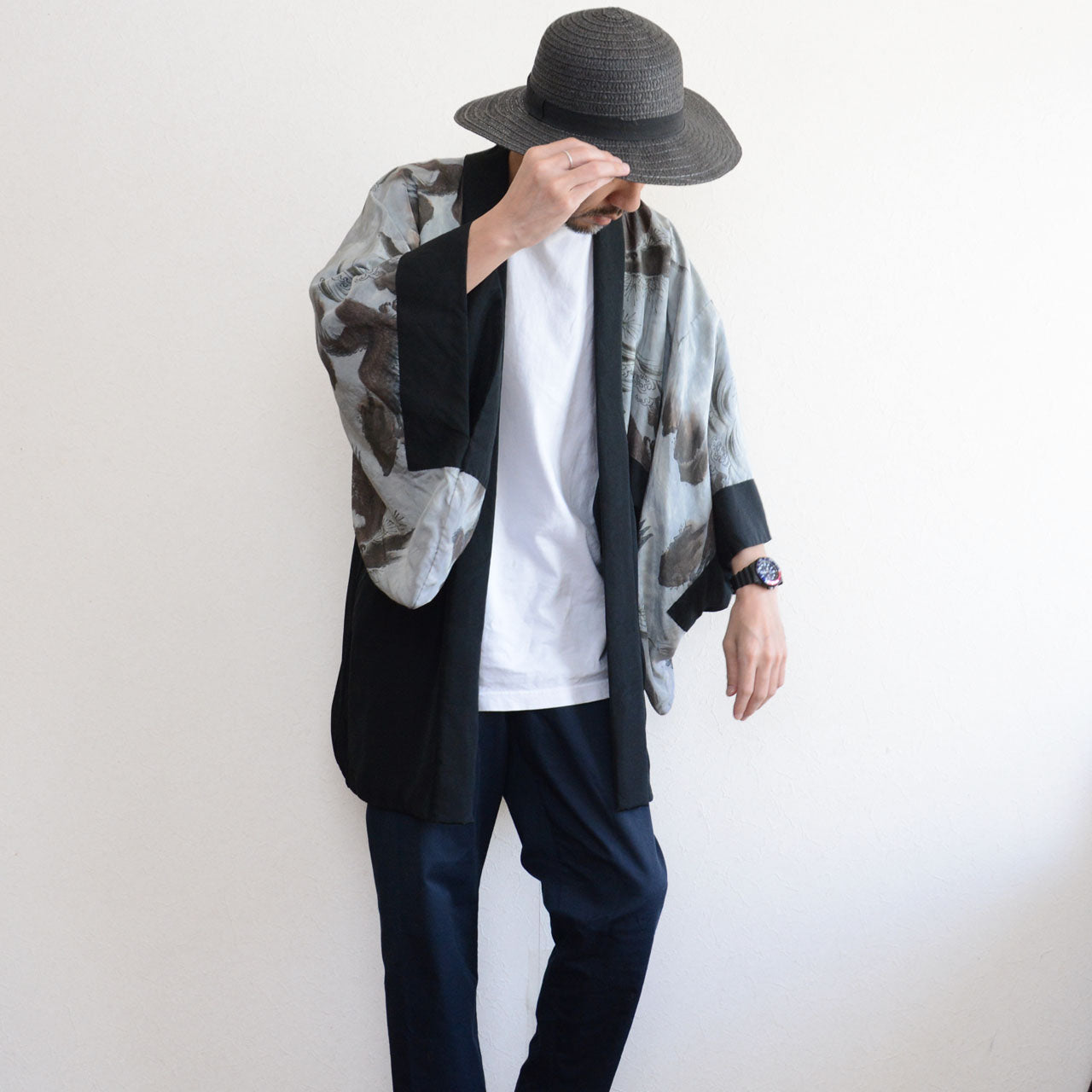 Model wearing black silk haori, three-quarter view, eagle lining visible at sleeve opening, casual street styling, model height 171 cm