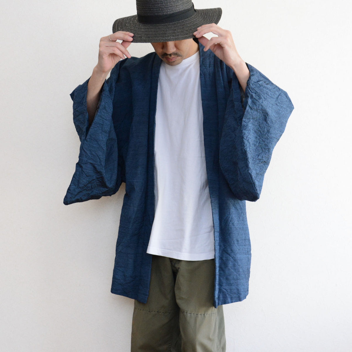 Men’s blue Japanese vintage haori jacket with a white T-shirt, olive trousers and dark hat
