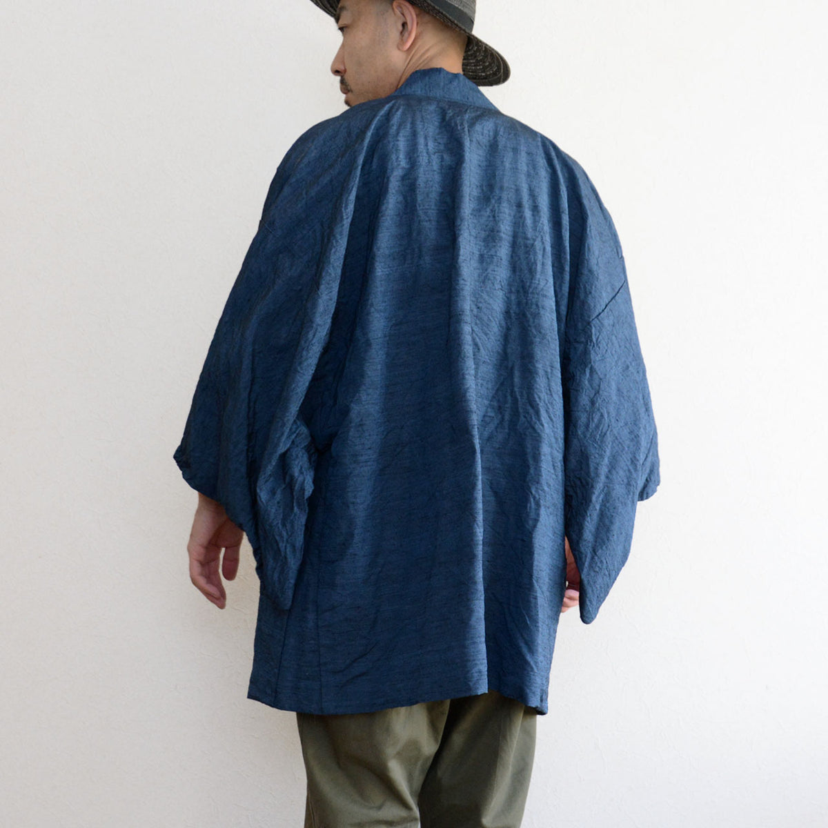 Blue vintage haori jacket with a center seam and wide sleeves, paired with olive trousers