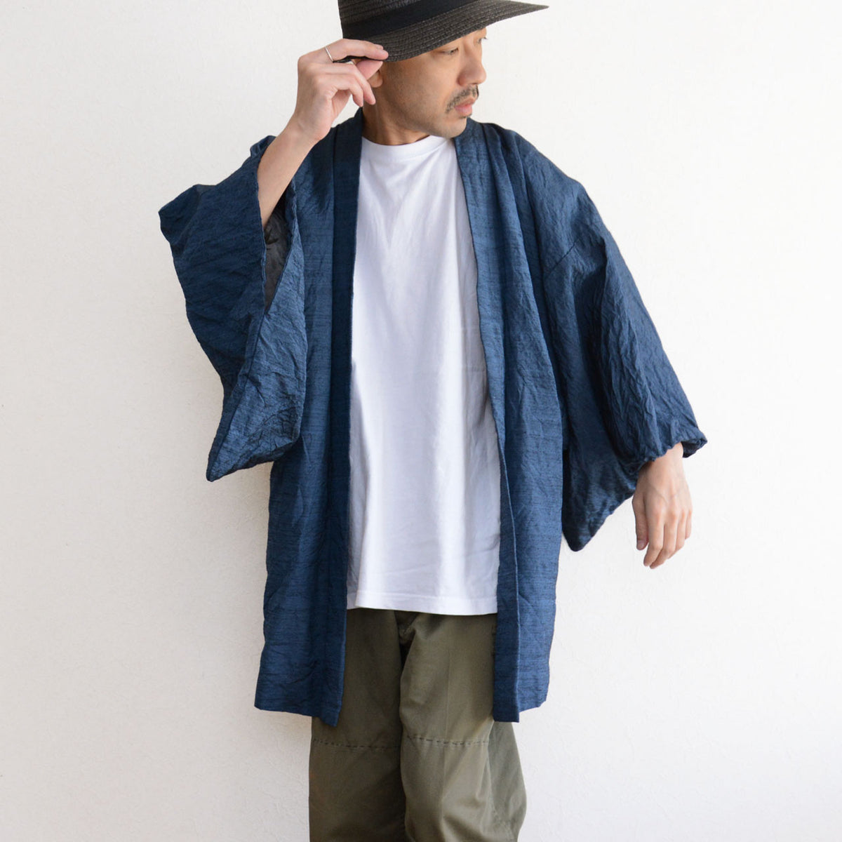 Men’s blue Japanese vintage haori jacket paired with a white T-shirt, olive trousers and dark hat