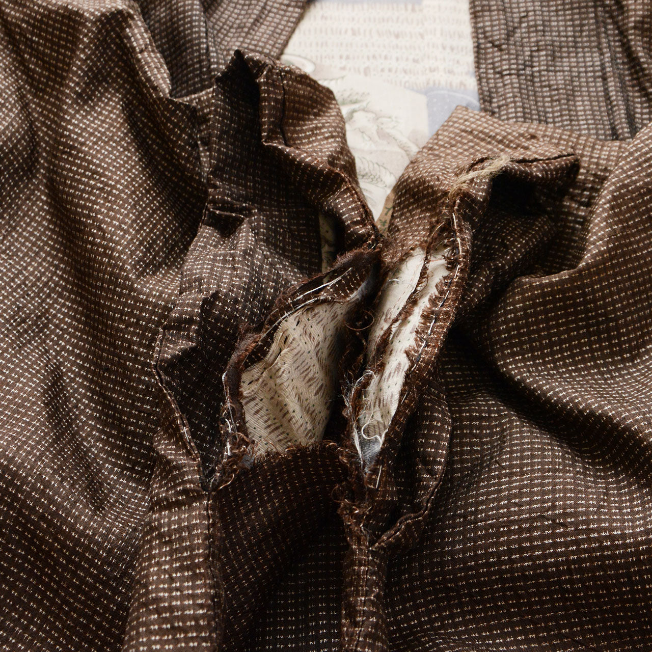 Sleeve cuff of men's Japanese vintage haori jacket showing fabric tear, brown silk komon weave, condition detail