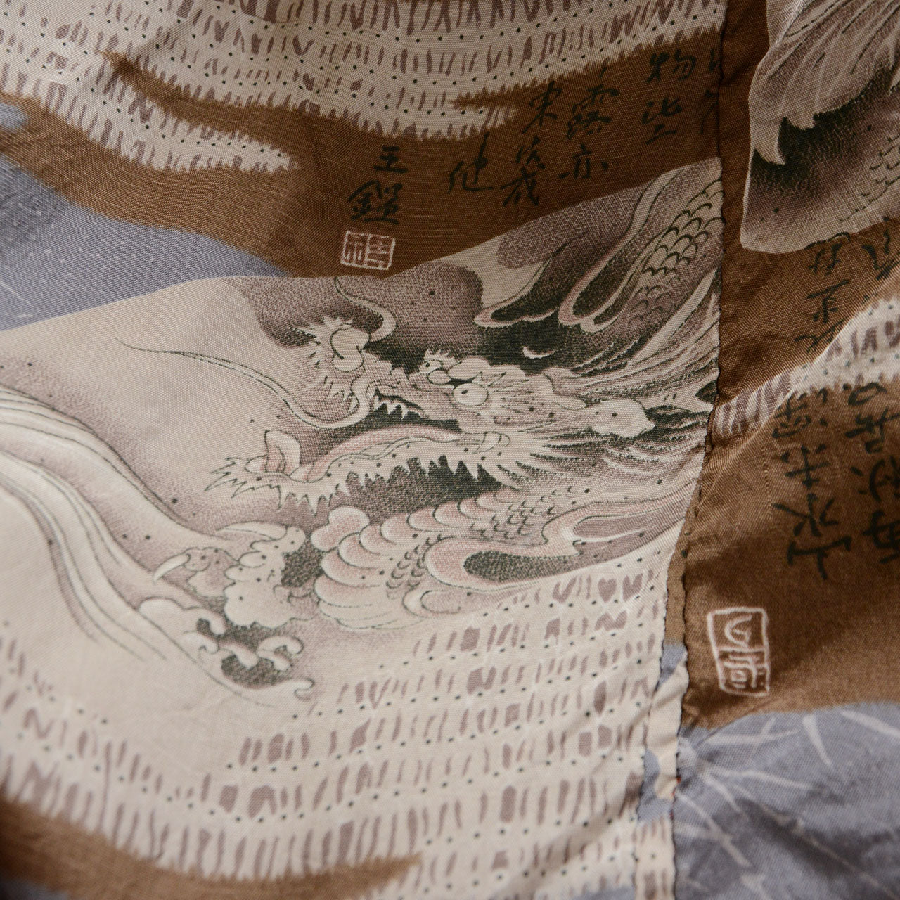Close-up of haori lining with hand-painted dragon, crashing waves, kanji text, and red seal stamp in brown, ivory, and blue, Showa era Japan