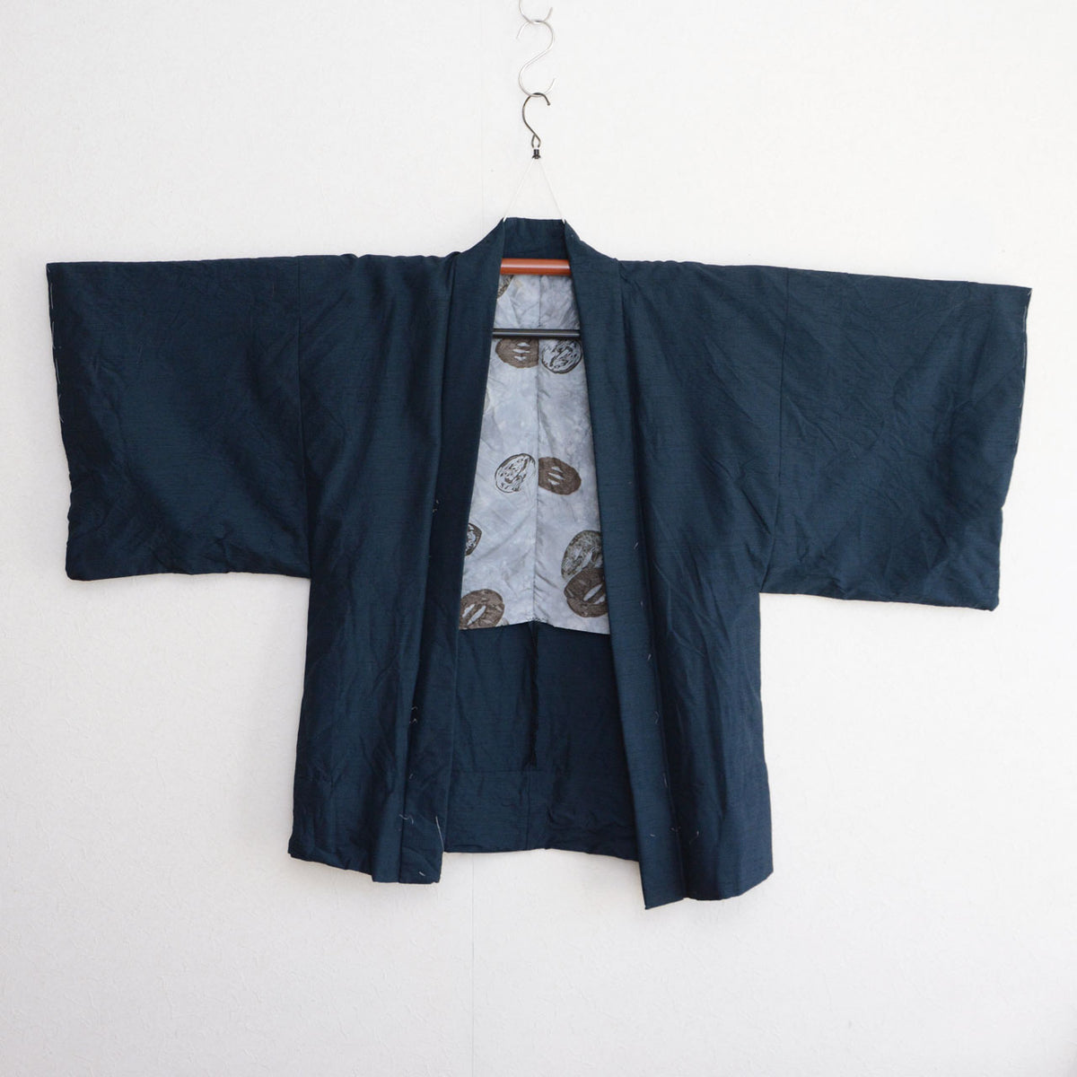 Deep blue-green Japanese vintage men's haori with wide sleeves and a light gray lining featuring tsuba sword-guard motifs.
