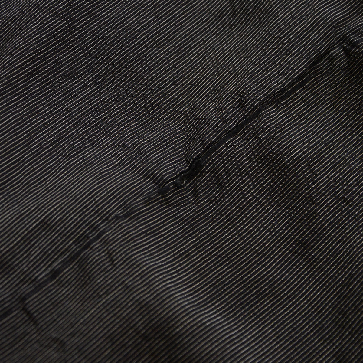 Long narrow tear in the striped sleeve fabric of a vintage haori