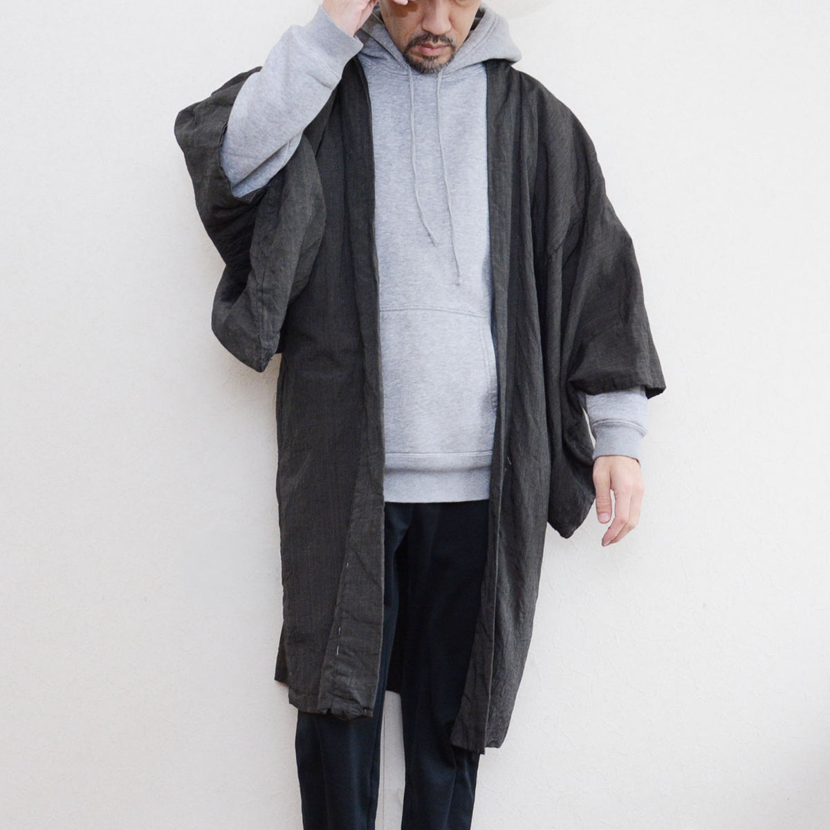 Fine-striped long men’s haori layered with a grey hoodie and dark trousers